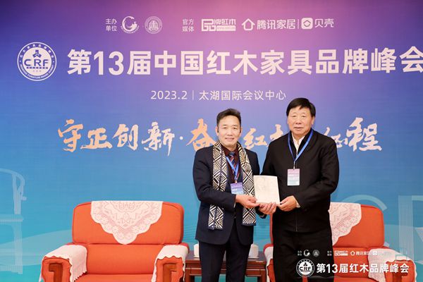 中共第十八屆中央委員、全國(guó)政協(xié)文化文史與學(xué)習(xí)委員會(huì)副主任葉小文（右）向優(yōu)秀紅木家具企業(yè)代表國(guó)方家居董事長(zhǎng)陳新平（左）贈(zèng)送個(gè)人著作